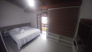 Un dormitorio con cama, armario y puerta que da a un área exterior.