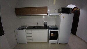 Una cocina compacta equipada con lavadora, microondas, estufa y refrigerador.