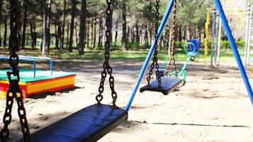 Children can play on the swings and slide in this park playground.