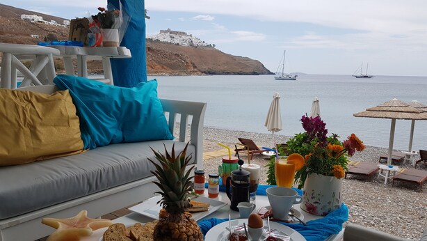 A breakfast setup with a pineapple, toast, and jam on a table by a seaside view. - Aegean Sea Villas (Astypalaia)