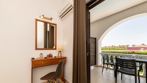 A balcony with a dining table and chairs, a wooden desk with a lamp, and a mirror. - Alterego Studios (Zakynthos)