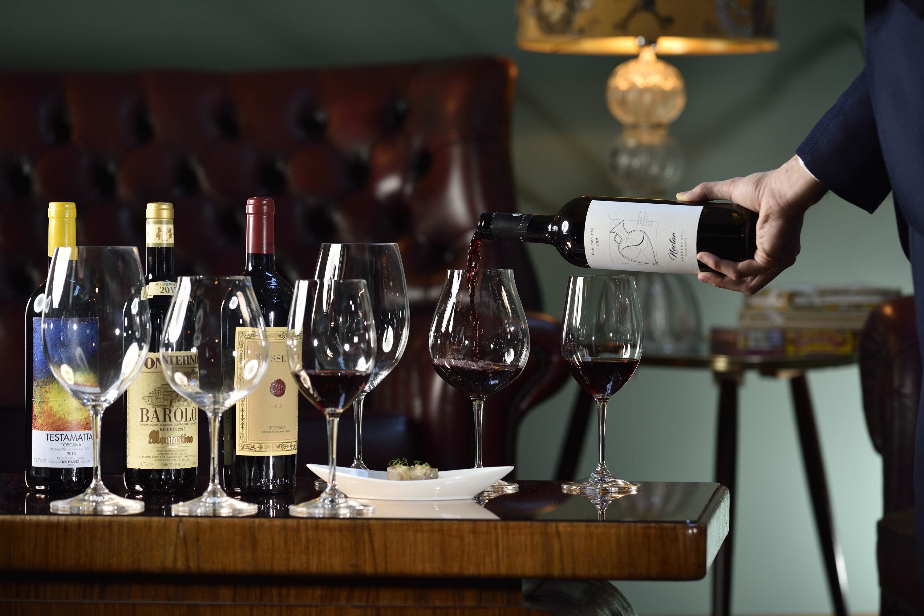 Un evento de degustación de vinos con varias botellas y copas sobre una mesa.