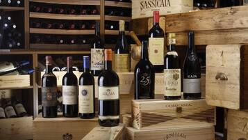 Une cave à vin avec des caisses en bois et des bouteilles de vin, notamment des marques comme Solaiia et Cassicata.