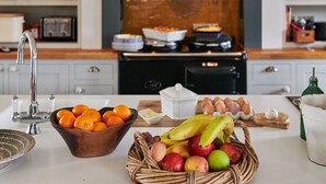 A kitchen with a wooden backsplash, a sink, and various kitchen appliances. - Church End Cottage (Newport Pagnell)