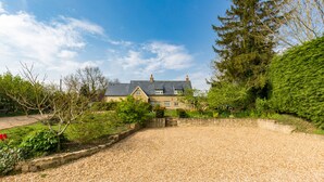 A house with a gravel driveway and a garden. - Church End Cottage (Newport Pagnell)