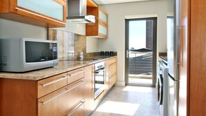 Una cocina moderna con electrodomésticos de acero inoxidable, armarios de madera y un ventanal con vistas a la ciudad.