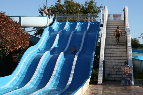 A water slide with multiple lanes and a person descending.