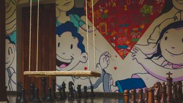 Un tablero de ajedrez con las piezas dispuestas en una habitación con un mural en la pared.