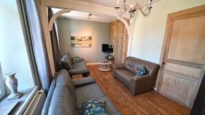 A living room with a sofa set, a coffee table, and a TV. - Holiday Home in Hotton near Caves of Hotton (Werpin)