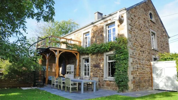 A stone house with a covered patio and a dining area. - Holiday Home in Hotton near Caves of Hotton (Werpin)