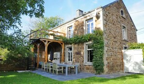 A stone house with a covered patio and a dining area. - Holiday Home in Hotton near Caves of Hotton (Werpin)