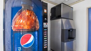 Un distributeur automatique orné du logo Pepsi et muni d’un robinet à eau.