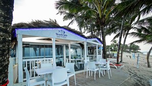 A beachside Italian restaurant with outdoor seating and palm trees. - Kitewind Apartahotel Cabarete (Cabarete)