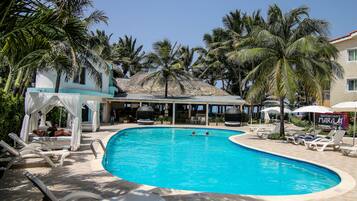 Una piscina al aire libre, sillones reclinables de piscina