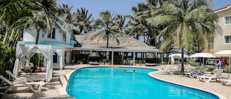 Una piscina al aire libre, sillones reclinables de piscina