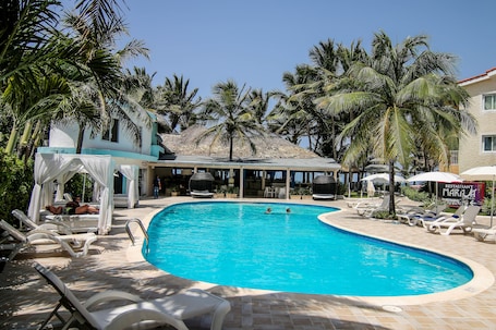 Una piscina al aire libre, sillones reclinables de piscina. Kitewind Apartahotel Cabarete
