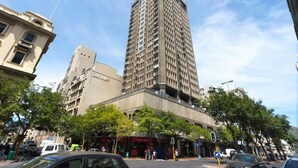 A tall building with a modern architectural style, featuring a grid-like facade and multiple windows.