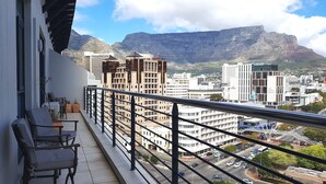 A balcony with a view of a cityscape and mountains.