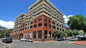 A multi-story hotel with a red brick facade and multiple balconies. - ITC Hospitality Group One Bedrooms Rockwell Building (Cape Town)
