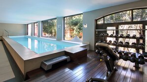 A gym with a swimming pool, exercise equipment, and large windows. - ITC Hospitality Group One Bedrooms Rockwell Building (Cape Town)