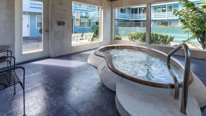 A spa area with a hot tub, large windows, and a view of the outside. - Travelodge by Wyndham Florence (Florence)