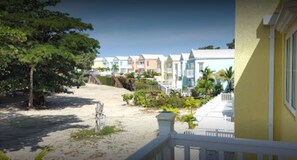A beachfront property with colorful houses, a sandy beach, and a view of the ocean. - Little Bay Country Club Resort Complex (Negril)