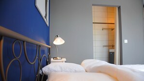 Une chambre d’hôtel avec un lit, une lampe de chevet et vue sur la salle de bain.