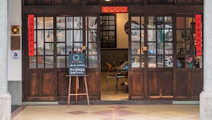 A hotel entrance with ornate architectural details, a signboard, and a visible interior with seating. - Originn (Taipei)