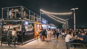 A food truck with outdoor seating and a crowd of people. - Originn (Taipei)