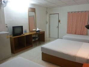 A hotel room with a bed, a desk with a computer, a television, and a wardrobe.