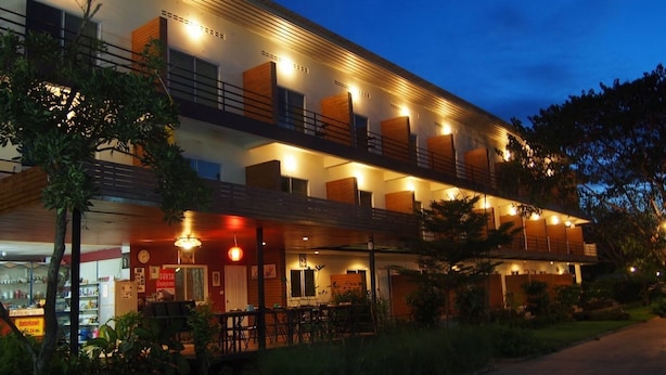 Een meerhoog hotel met terras en een restaurantgedeelte.