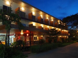 Un hotel de varios pisos con terraza exterior y zona de restaurante.
