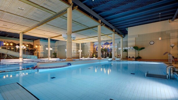 Une piscine intérieure avec des couloirs clairement délimités, un vestiaire et un espace d’accueil.