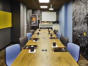 A conference room with a long table, chairs, a projector, and a whiteboard. - ibis Paris Gare de l'Est 10ème (Paris)