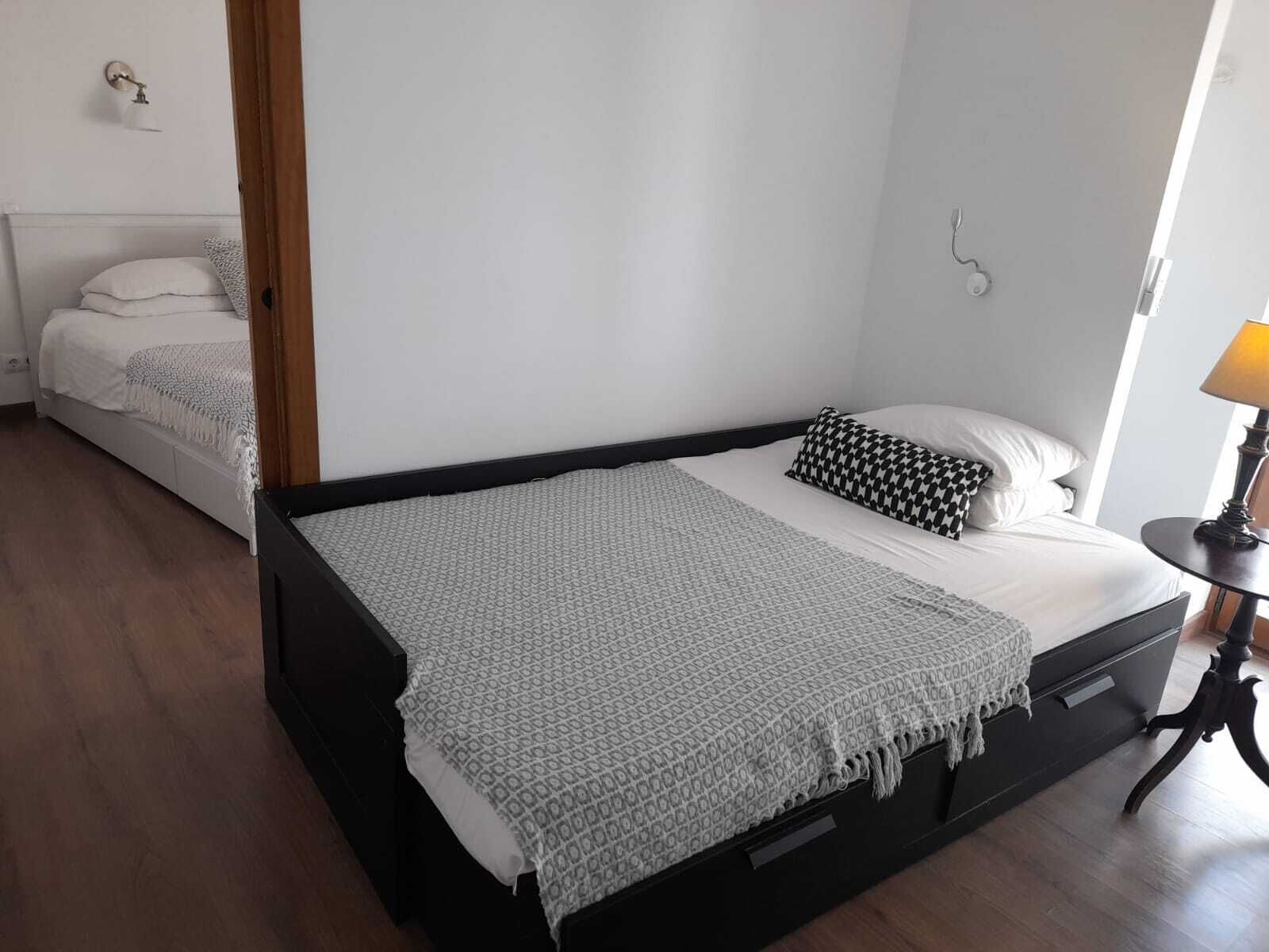 Une chambre à coucher avec un lit, une table de chevet et une lampe.