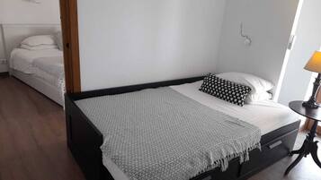 Une chambre à coucher avec un lit, une table de chevet et une lampe.
