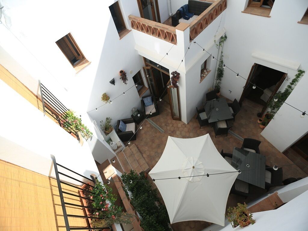 A multi-level courtyard with outdoor seating, string lights, and potted plants.