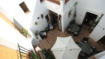 A multi-level courtyard with outdoor seating, string lights, and potted plants.