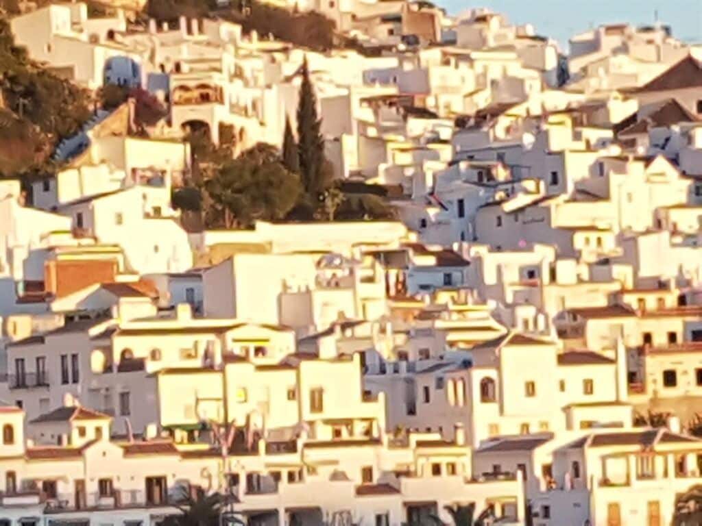 Zona urbana densamente poblada con edificios blancos muy juntos, probablemente un barrio residencial o comercial.