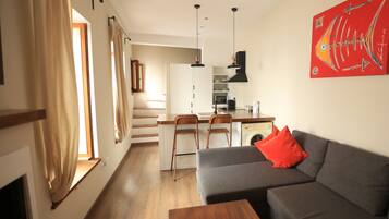 A modern apartment with a kitchen, dining area, and living room.