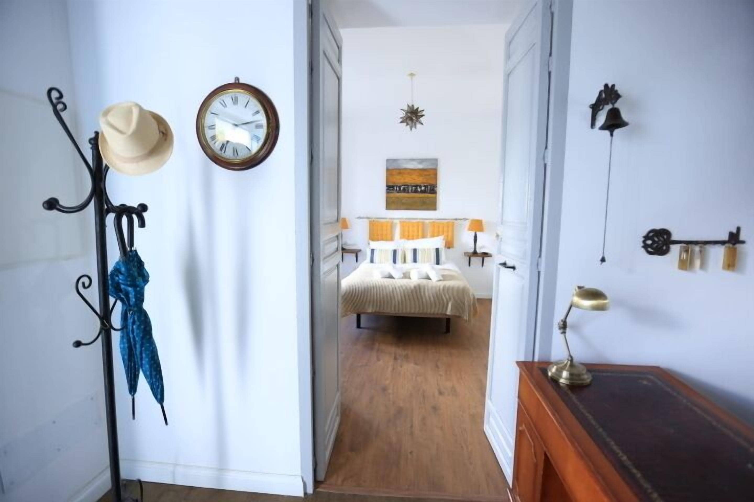 Une chambre à coucher avec un lit, une horloge et une lampe fixée au mur.
