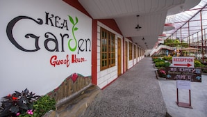Een gang met een bordje voor 'KEA Garden Guest House' en een receptie met een bord 'Verboden toegang' voor gasten.