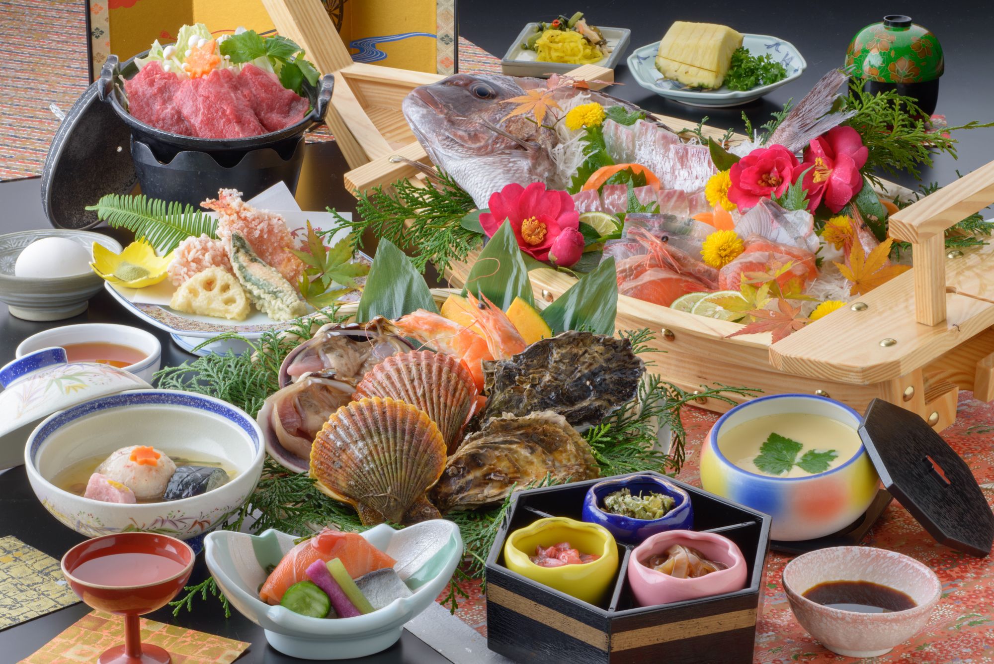 A variety of seafood dishes, including fish, shrimp, and oysters, arranged on a table with bowls of dipping sauces and decorative flowers.