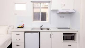 A compact kitchen with a sink, a microwave, and a refrigerator.