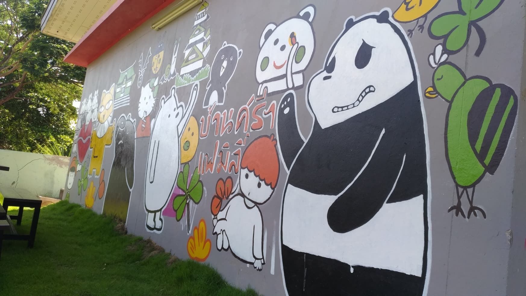 A wall with colorful cartoon characters and Thai text.