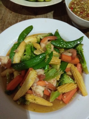 A plate of stir-fried vegetables including corn, carrots, and green peppers. - Stella Resort (Sam Roi Yot)