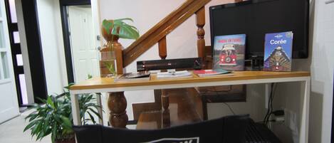 A home office setup with a desk, computer, and two books.