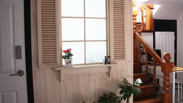 Un escalier en bois avec une rampe blanche et une porte en bois dotée d’un trou de serrure.