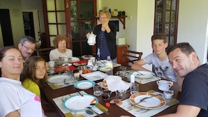 A family dining at a table with various dishes, cups, and a bottle.