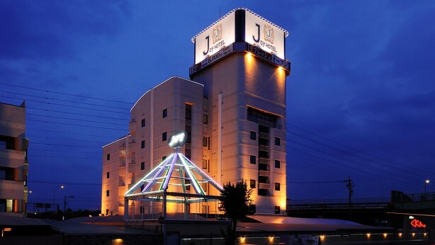 A hotel with a prominent tower and a distinctive triangular glass structure. - Hotel Joy -Adult Only (Komaki)